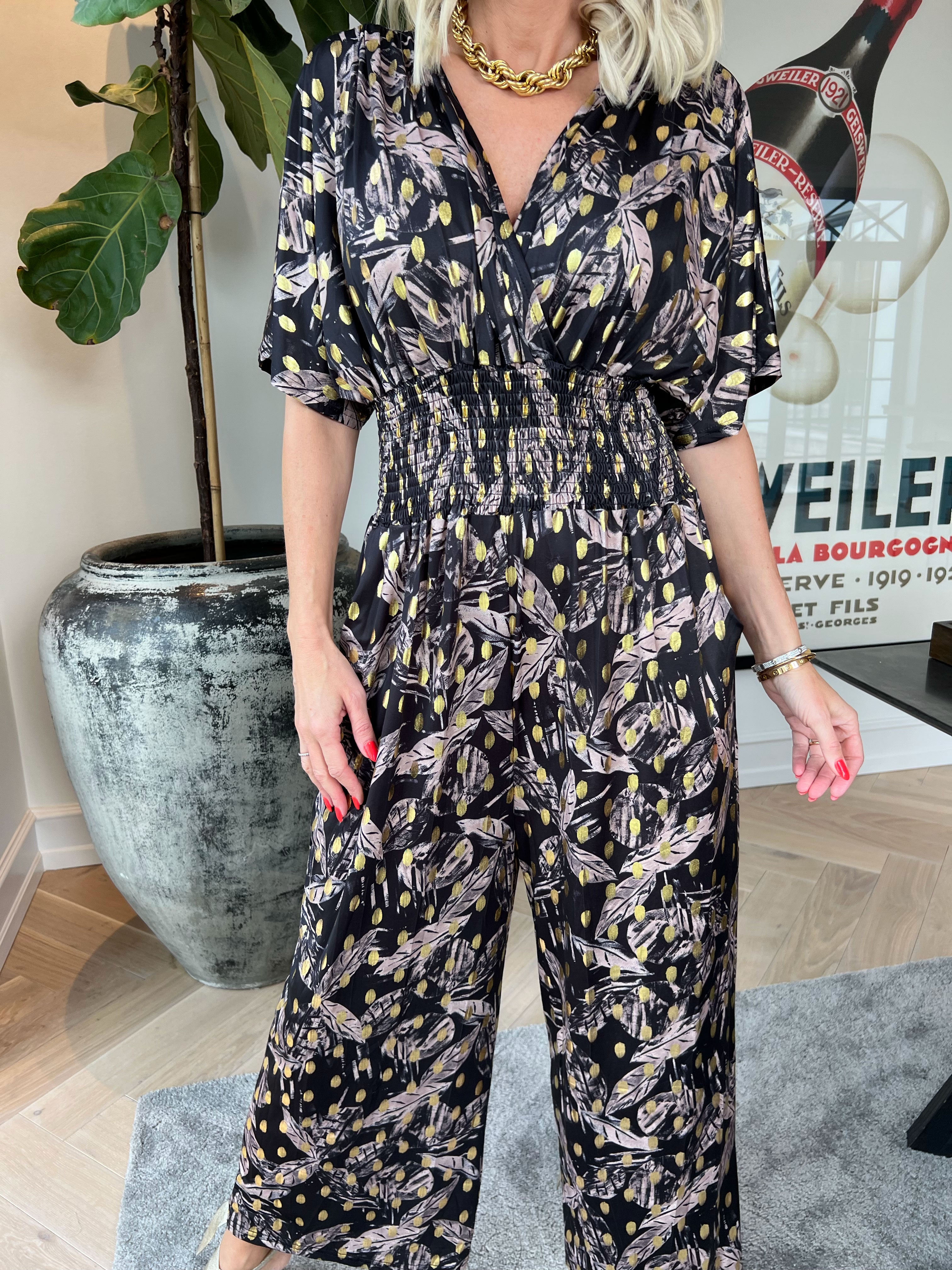 Pams Leafage Jumpsuit - Elastisk jumpsuit i lövmönster med guldfärgade tofsar